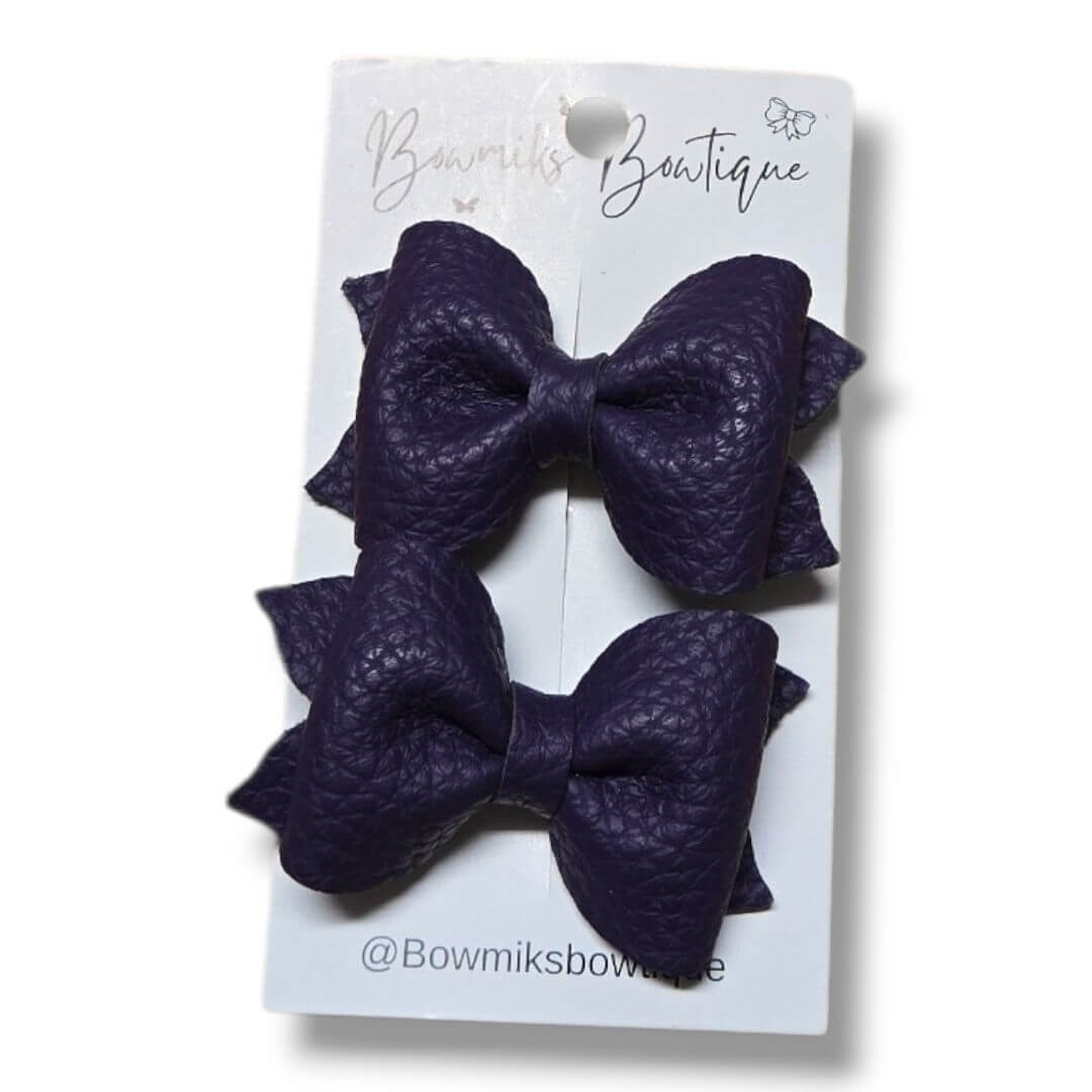 Handmade boutique hair accessories featuring stylish purple leather bows from Bowmiks Boutique.