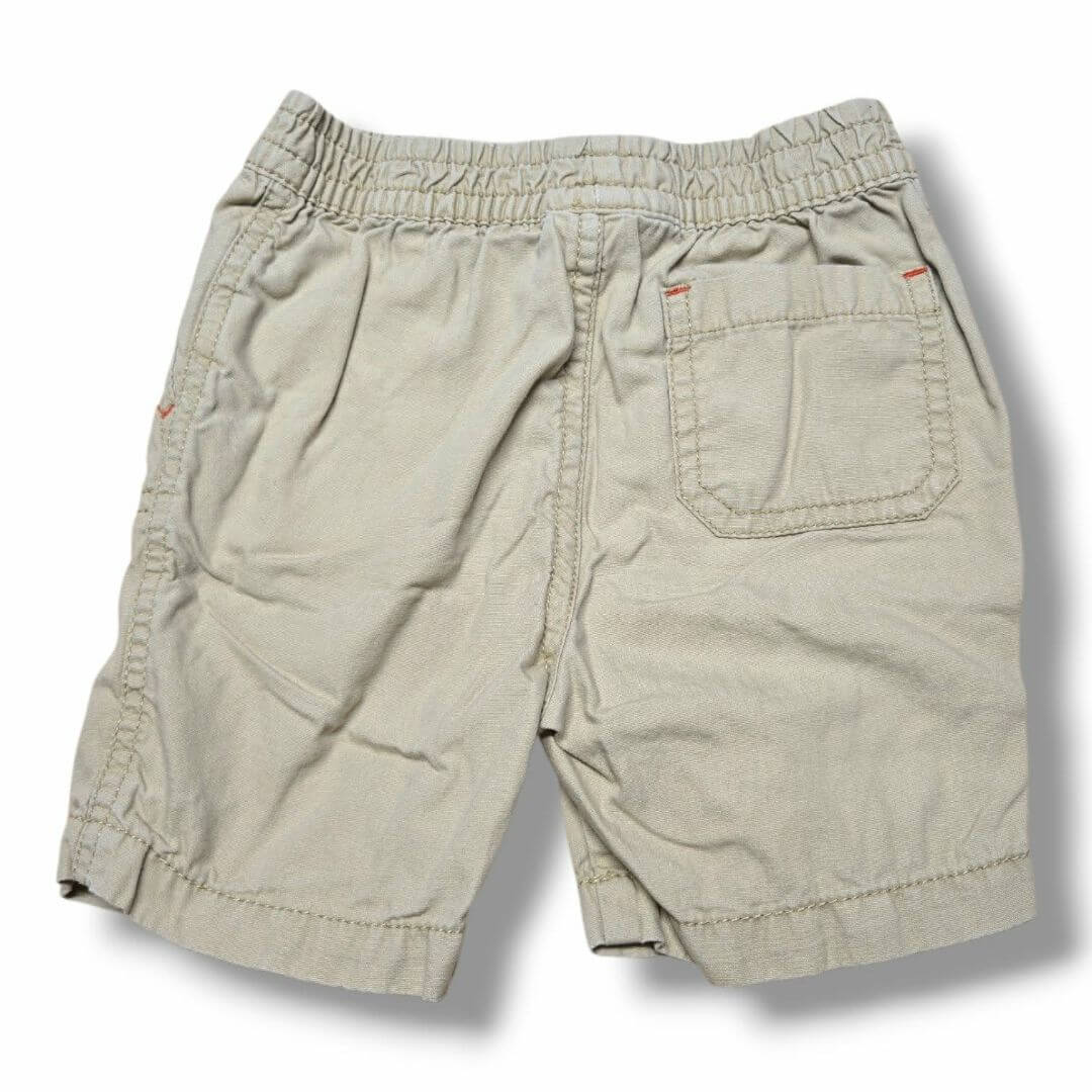 Pre-loved children's shorts in beige with elastic waistband and back pocket, inspected for quality.