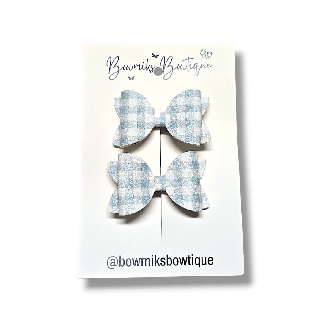 Handmade light green pigtail bow clips from Bowmiks Boutique displayed on a card.