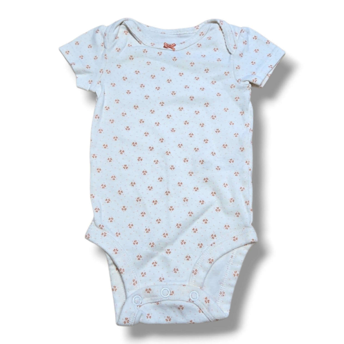 Pre-loved baby onesie with floral pattern and snap closures, perfect for layering and everyday wear.