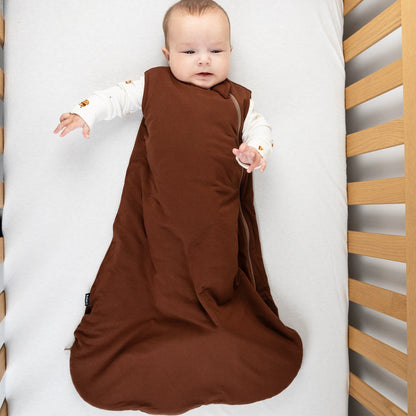 Baby wearing a cocoa bamboo sleep sack for babies, designed for comfort and movement in a crib.