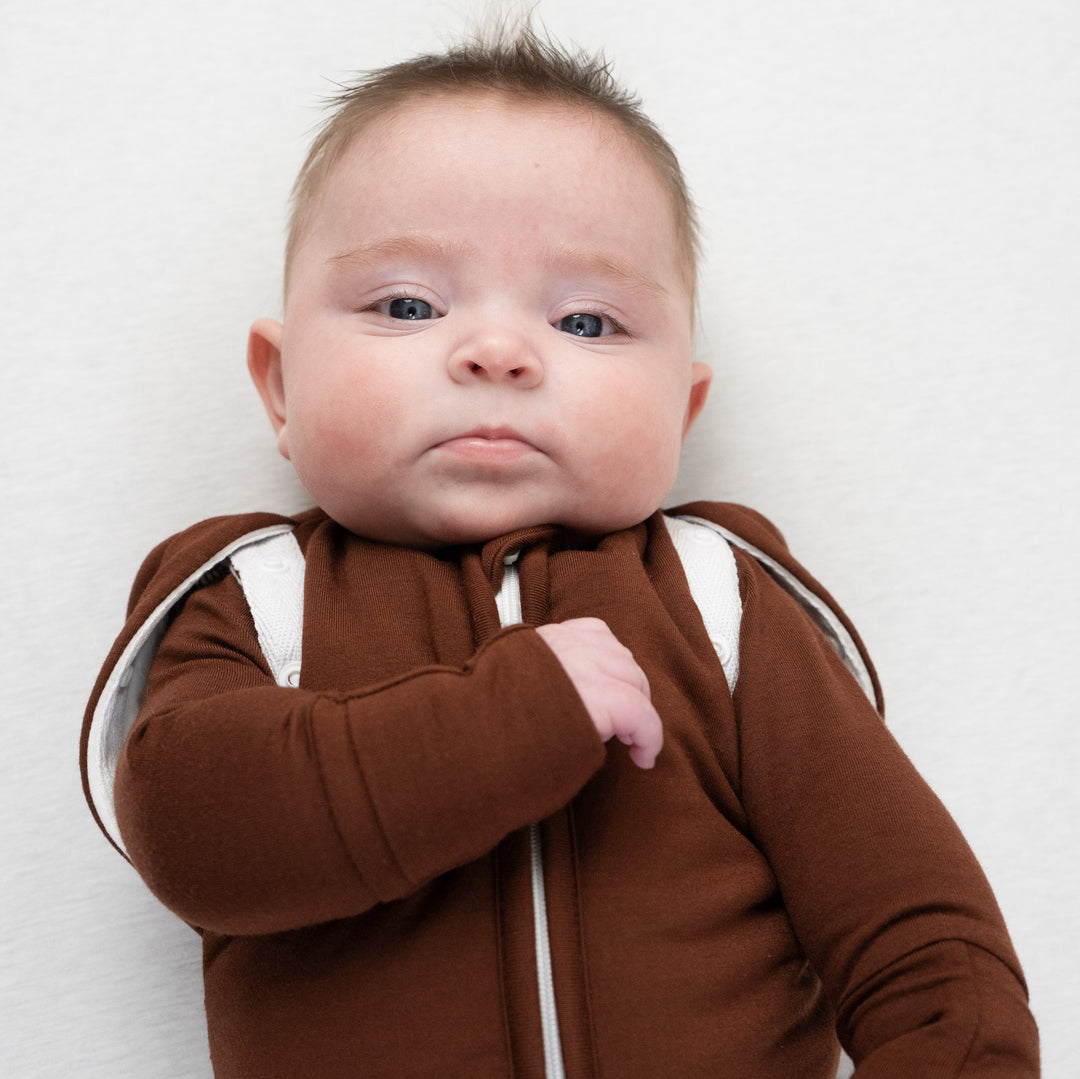Baby wearing a convertible swaddle sack cocoa with a snug fit and stylish design.