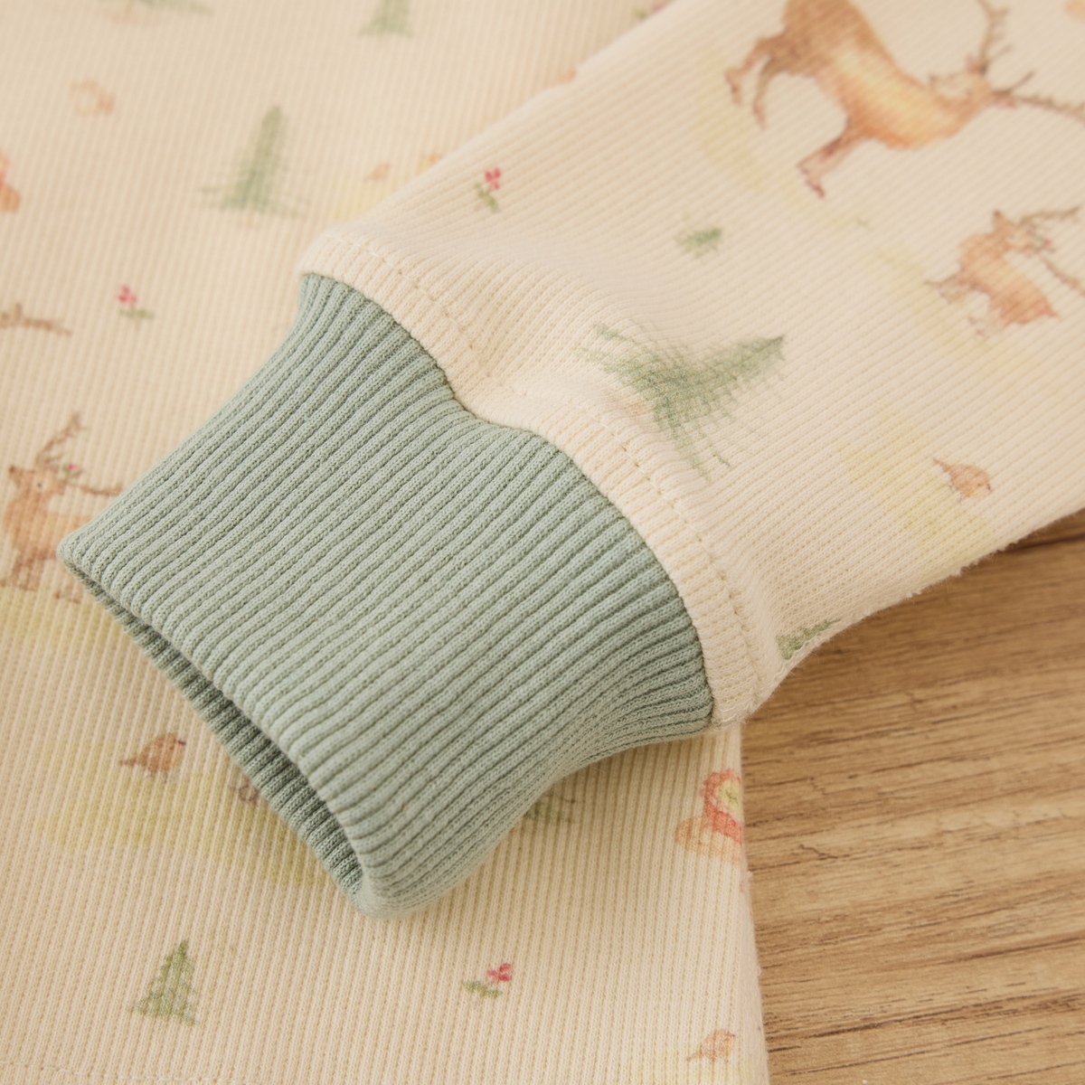 Detail of Blara Organic House organic ribbed henley pajama set showing ribbed cuffs and playful floral pattern.