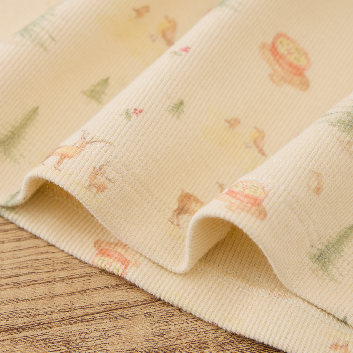 Organic ribbed henley pajama set fabric with playful print featuring animals and nature motifs.