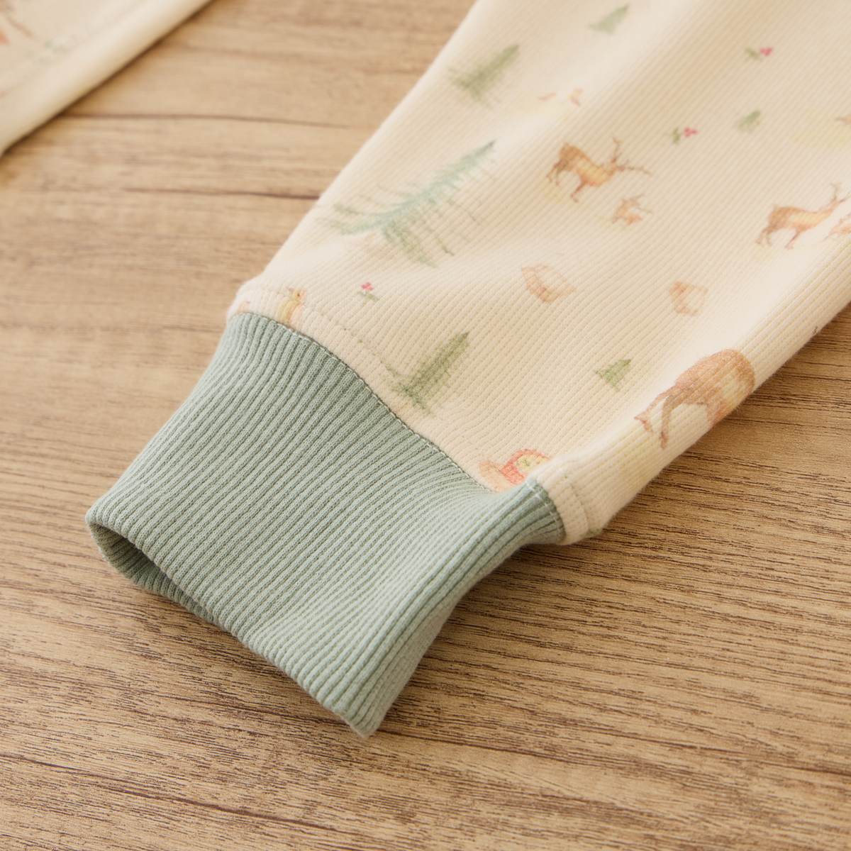 Close-up of ribbed cuff from Blara Organic House organic ribbed henley pajama set on wooden surface.