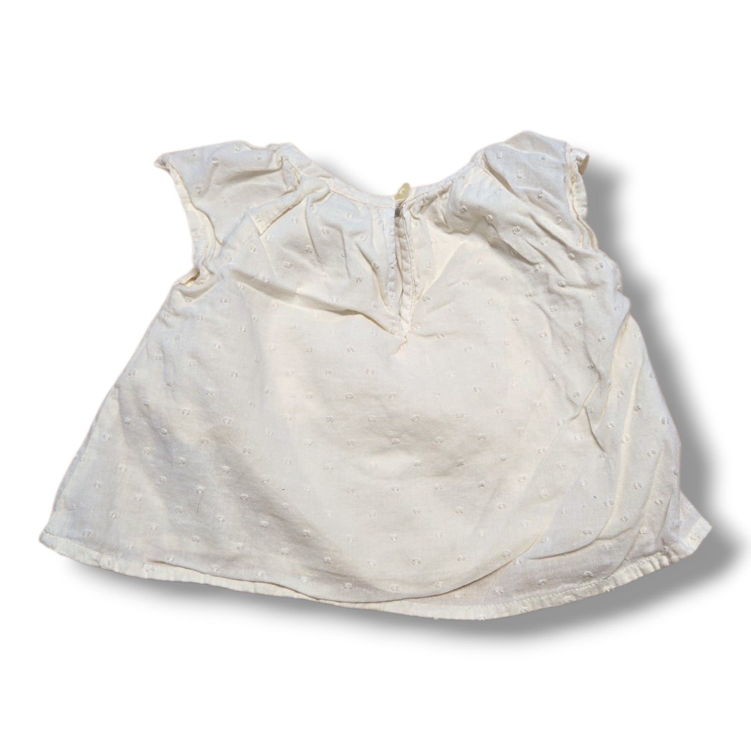 Old Navy preloved baby t-shirt 3-6 months with flutter sleeves in cream color and Swiss dot fabric.