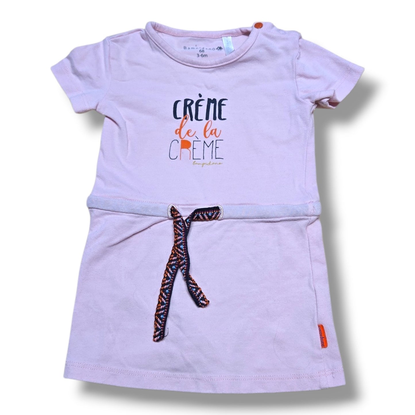 Pre-loved baby dress 3-6 months in soft blush pink with 'Crème de la Crème' graphic and braided waist tie.