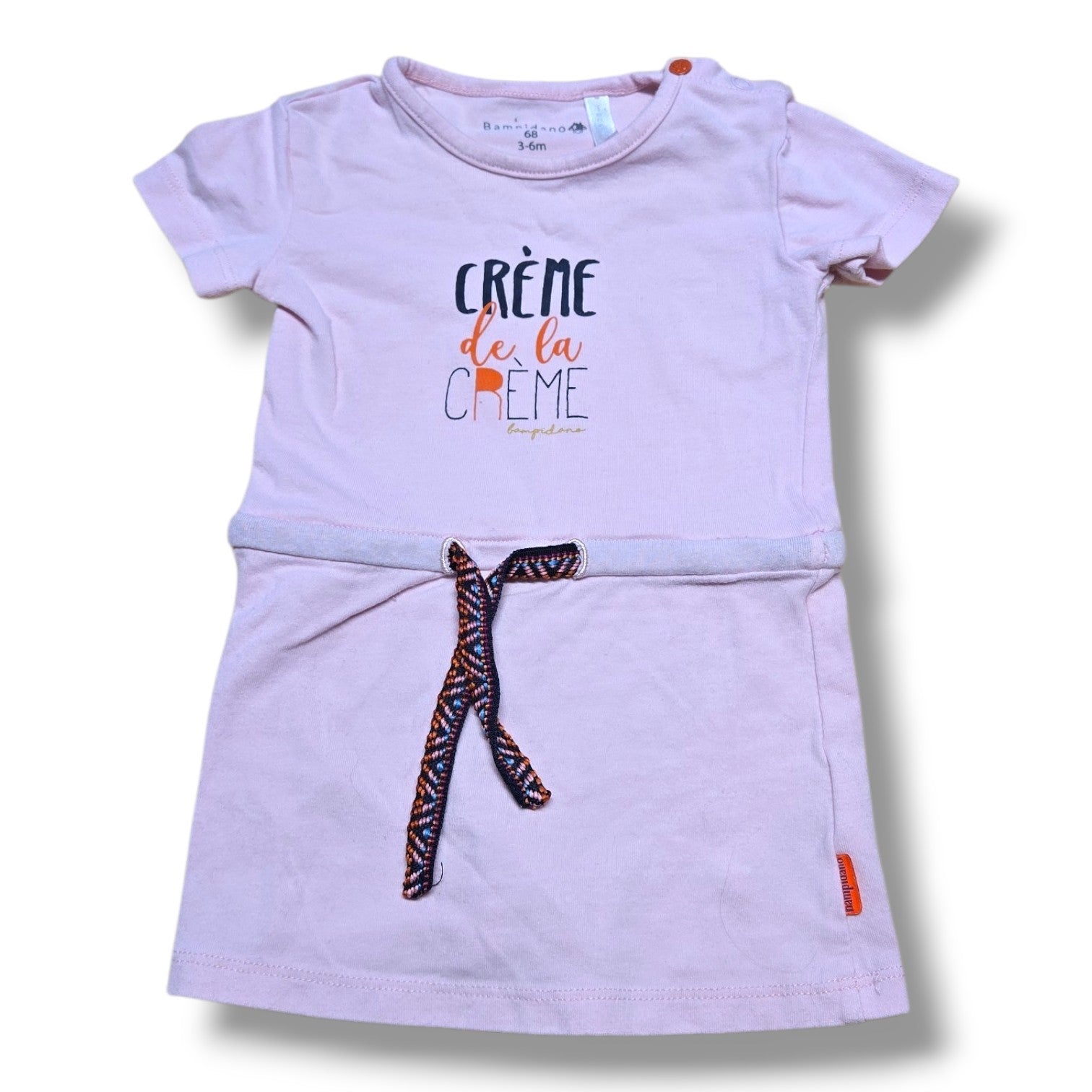 Pre-loved baby dress 3-6 months in soft blush pink with 'Crème de la Crème' graphic and braided waist tie.