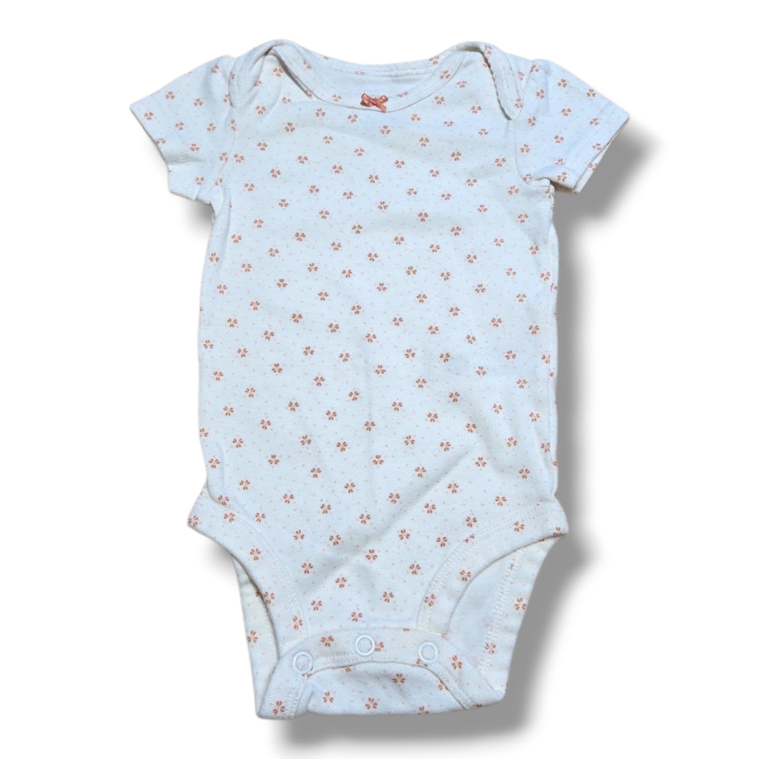 Pre-loved baby onesie with floral pattern and snap closures, perfect for layering and everyday wear.
