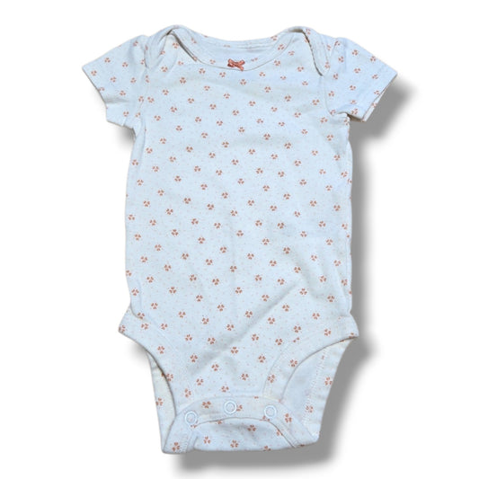 Pre-loved baby onesie with floral pattern and snap closures, perfect for layering and everyday wear.