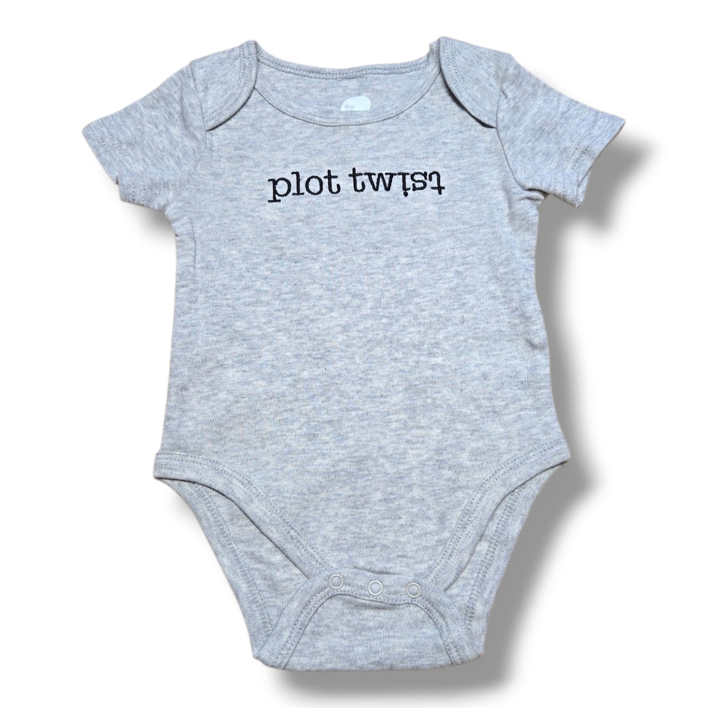 The Littlest pre-loved baby onesie in grey with plot twist printed design, perfect for fun outfits.