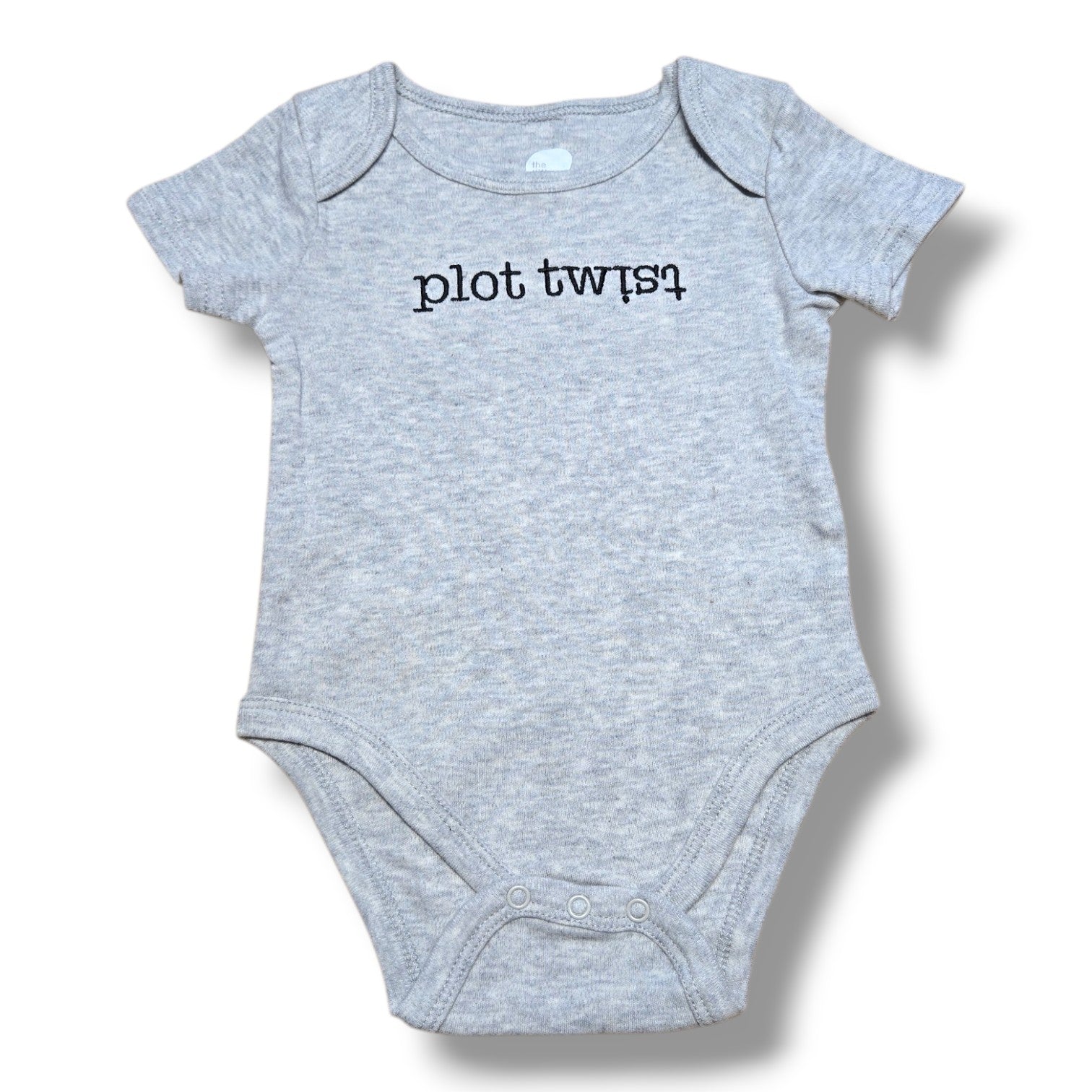 The Littlest pre-loved baby onesie in grey with plot twist printed design, perfect for fun outfits.