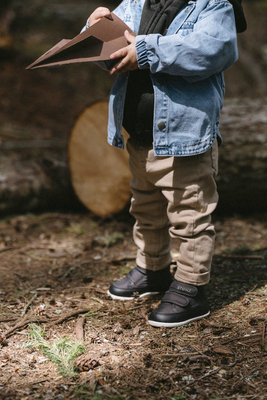 Toddler wearing Stonz Journey shoes in black, perfect for outdoor adventures and active play. toddler adventure shoes.