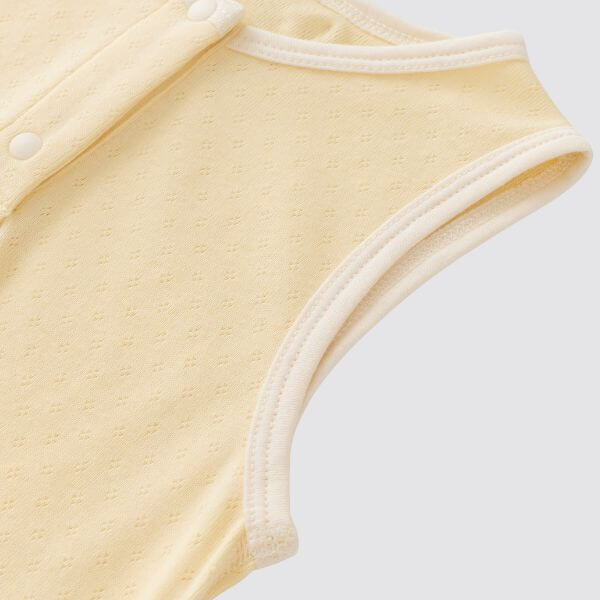 organic cotton sleeveless baby bodysuit in creamy yellow color, showcasing soft fabric and sleeveless design.