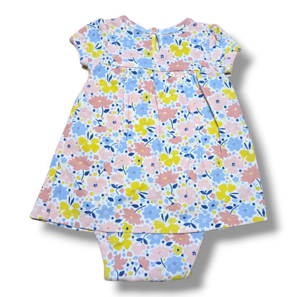 Pre-loved floral romper 3-6 months with pastel pink, yellow and blue floral print and bow detail.
